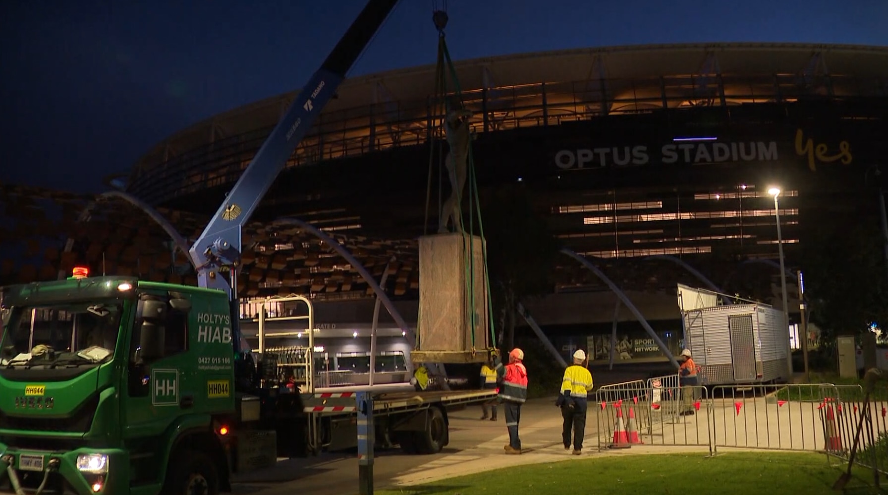A crane removes the statue of Nicky Winmar.