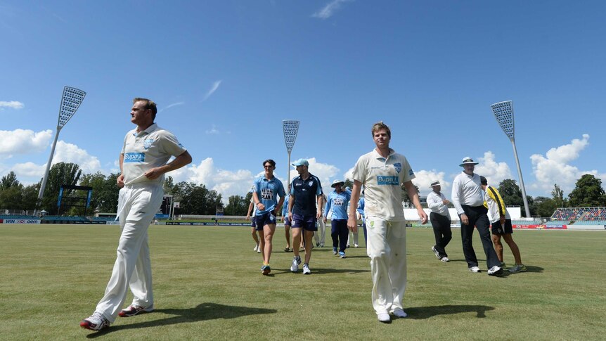 The Blues' Doug Bollinger (L) and Steve Smith walk off Manuka Oval after NSW beat Western Australia.