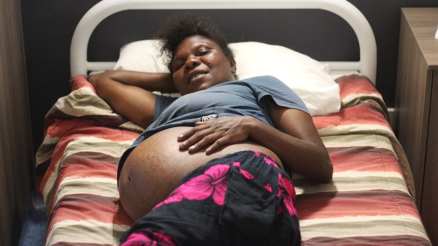 a pregnant woman lying on a bed