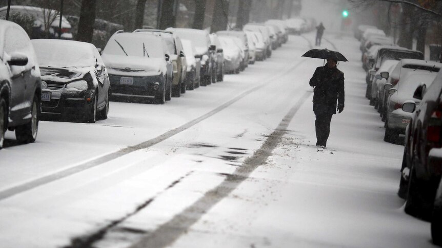 A man walks in the snow after a winter storm arrived in Washington