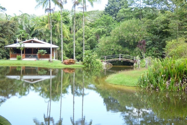 A house surrounded by trees with a large lake in the foreground.