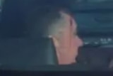 Luke Smith with blood on his temple in the back of an unmarked police car on July 20, 2018.