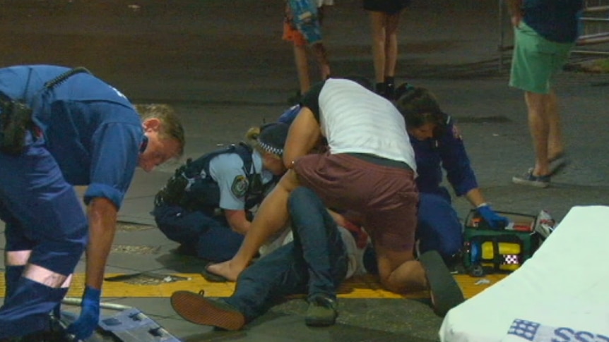 A 21-year-old man is treated by ambulance paramedics after he was bashed on Campbell Parade, Bondi.