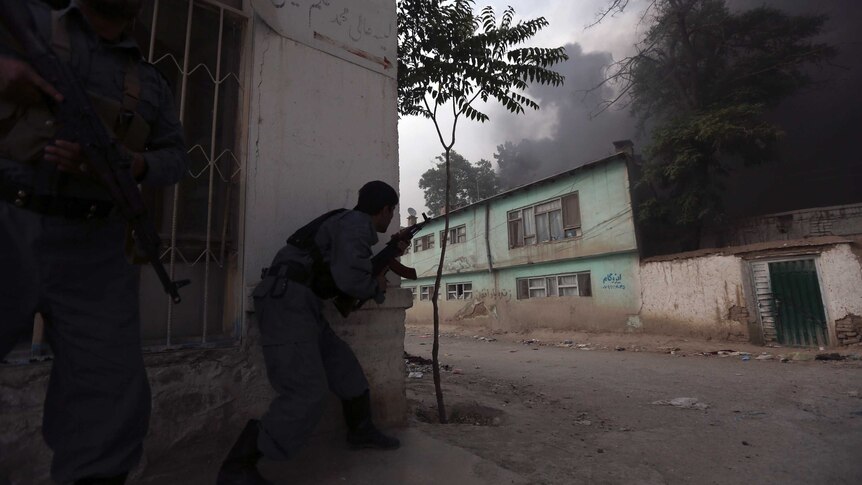Afghan policemen take up position as smoke billows from the site of an explosion in Kabul