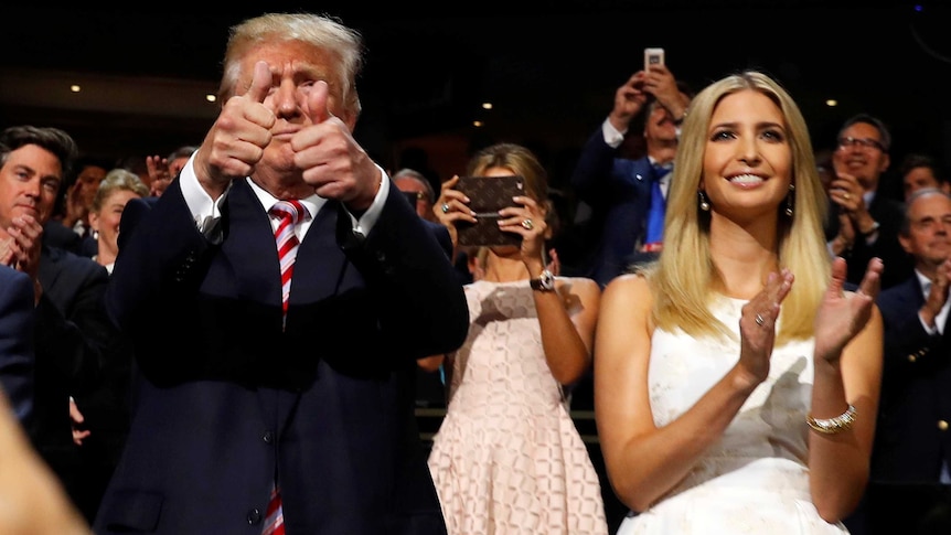 Republican US presidential nominee Donald Trump gives two thumbs up. Ivanka Trump stands beside him clapping.