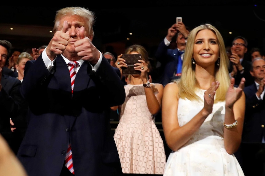 Republican US presidential nominee Donald Trump gives two thumbs up. Ivanka Trump stands beside him clapping.