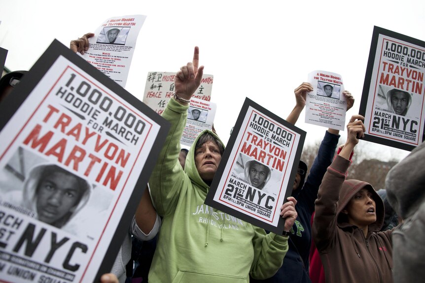 People hold up signs during a protest called A Million Hoodies March