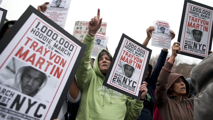 People hold up signs during a protest called A Million Hoodies March