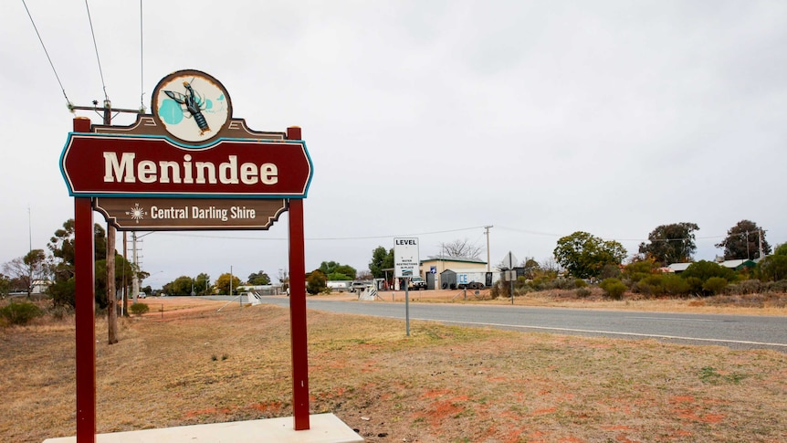 A sign saying "Menindee" on the side of a country road.