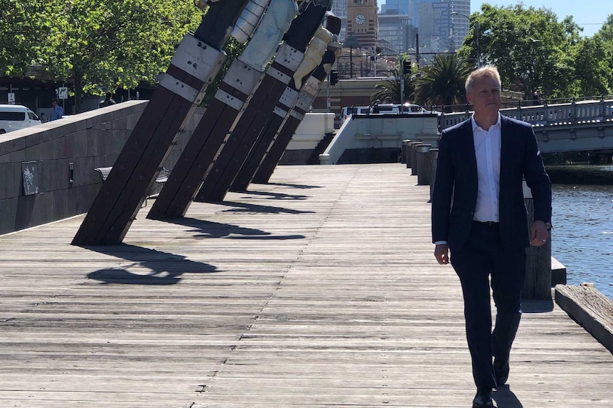Acting Lord Mayor Arron Wood walks along the Yarra River on a sunny day.