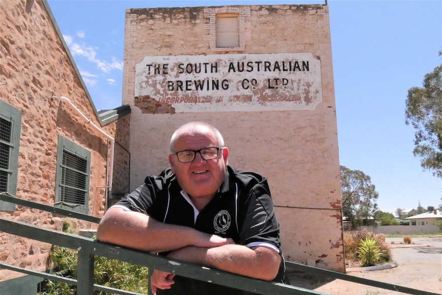 Broken Hill resident Paul Pearce resting on a hand rail in front of the Old Broken Hill Brewery