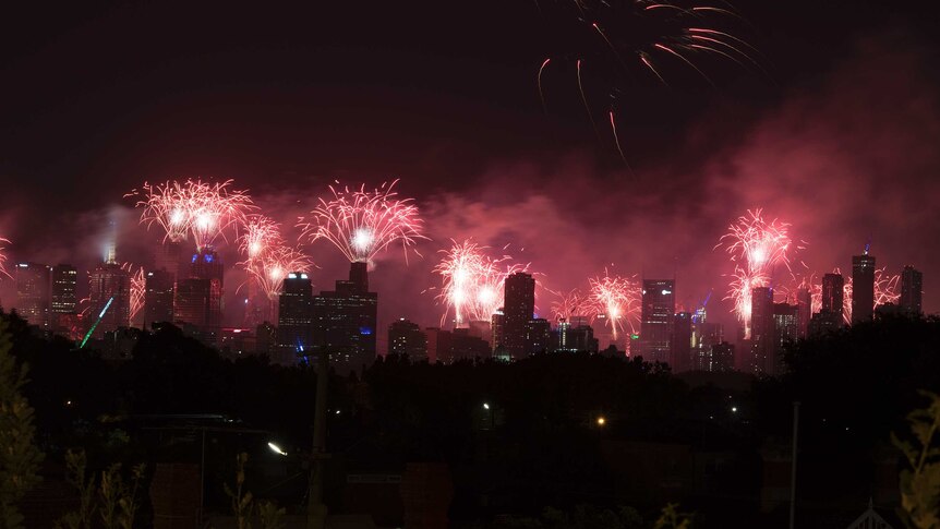 Fireworks go off over Melbourne's city skyline at night.