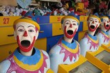 A row of plastic clown faces used as an amusement game at country shows
