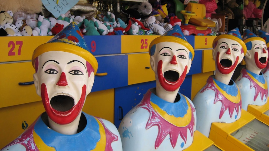 A row of plastic clown faces used as an amusement game at country shows