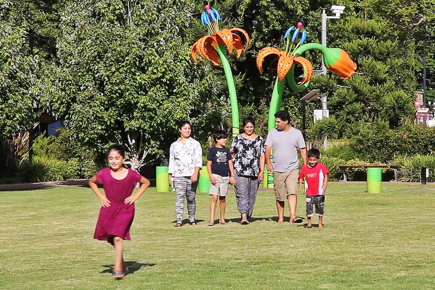 A family walks side by side in a Toowoomba park