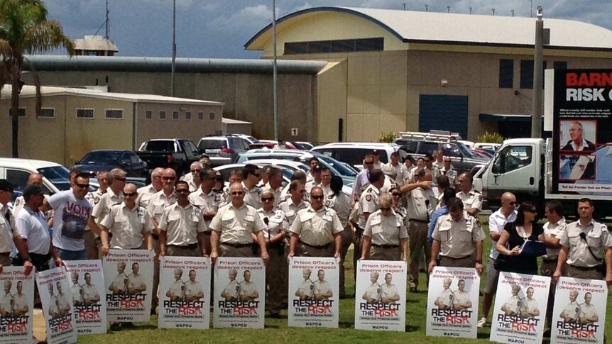 Prison officers hold signs outside Hakea prison