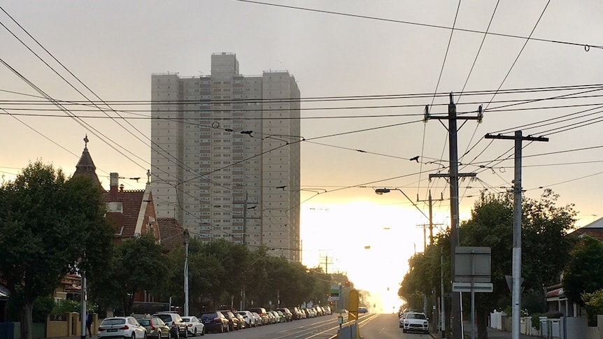 A street showing a high rise public housing tower in the distance.