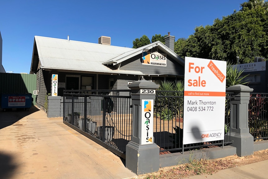 A "for sale" sign in front of the Oasis Backpackers in Mildura.