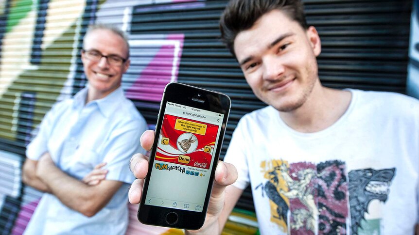 FunCaptcha founders Kevin Gosschalk and Matthew Ford, holding a mobile phone, in Brisbane in August 2017.