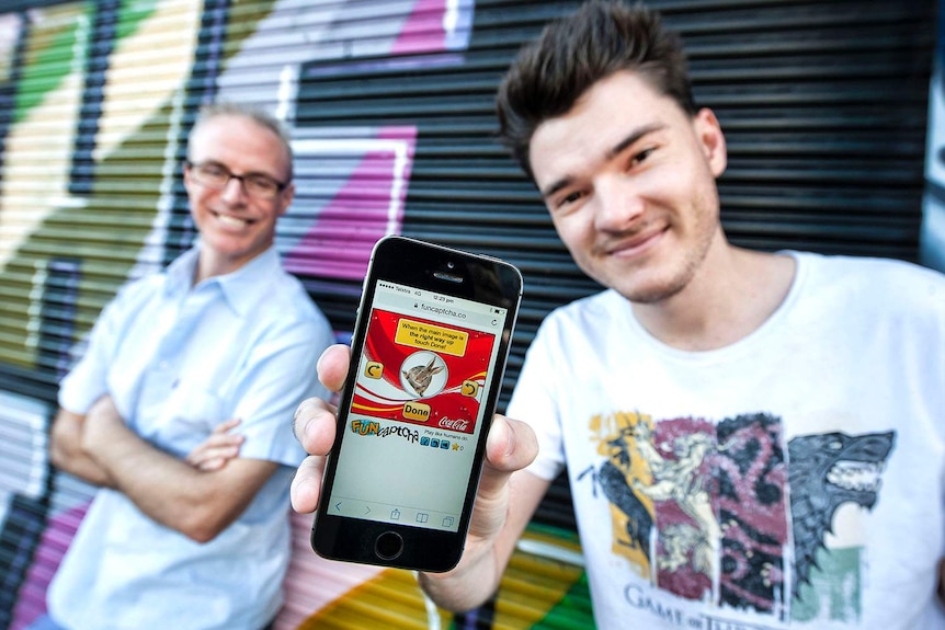 FunCaptcha founders Kevin Gosschalk and Matthew Ford, holding a mobile phone, in Brisbane in August 2017.
