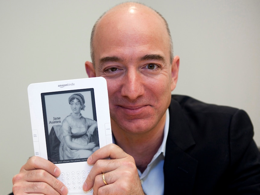 Jeff Bezos holds a Paperwhite Kindle. 