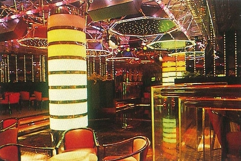 A flashy lounge in floating hotel with gold-coloured surfaces and bright lights.