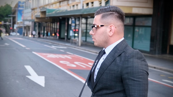 A man wearing a suit and tie and sunglasses.