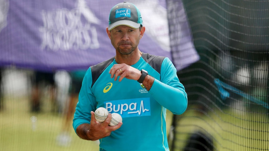 Ricky Ponting carries a number of cricket balls while wearing Australian training gear.