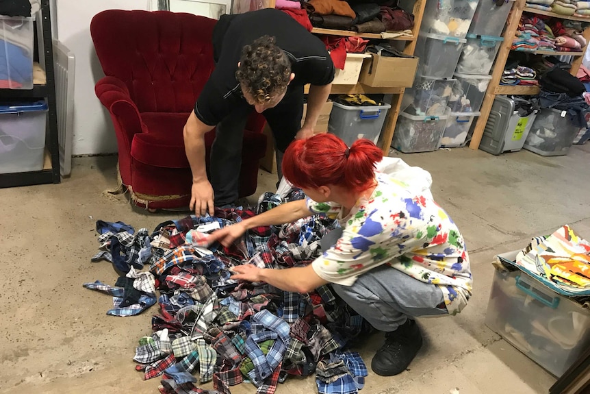 Christian Olea and Bex Frost sort through a pile of off-cuts on the floor of their workshop