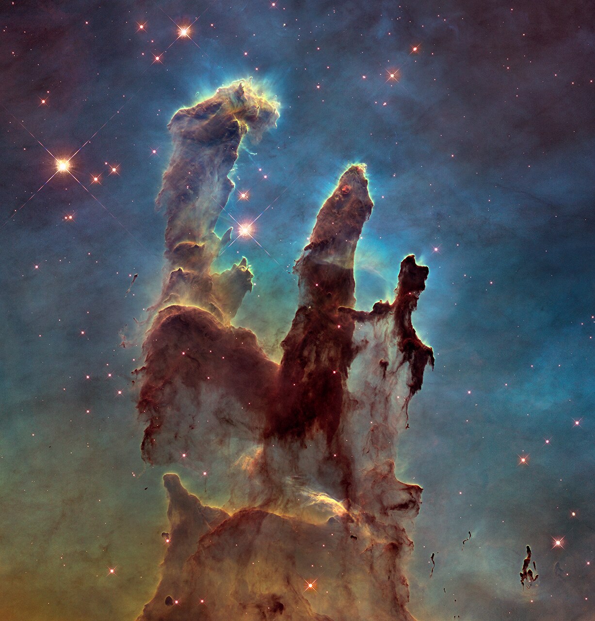 A detailed image of the Pillars of Creation, showing reddish purple dust clouds on a greenish-black background.