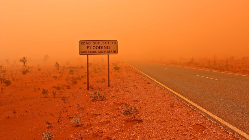 A dust storm blows across a remote highway near Exmouth in WA's Pilbara region.