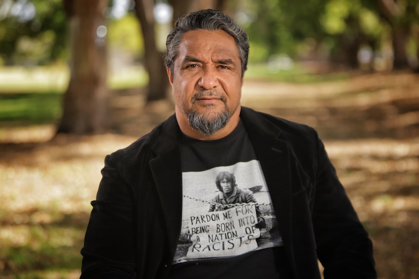 A man wearing a black shirt under a black jacket.