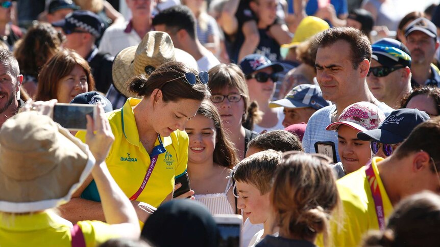 Swimmer Cate Campbell signs autographs for waiting fans at a a public event.