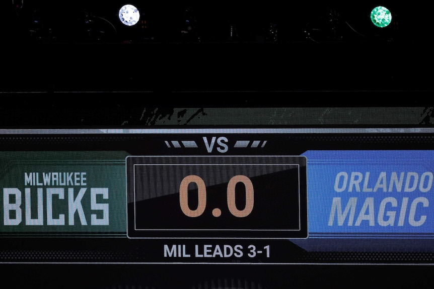 An electronic scoreboard has the time at '0.0' and reads 'MILWAUKEE BUCKS V ORLANDO MAGIC'. 'MIL LEADS 3-1'