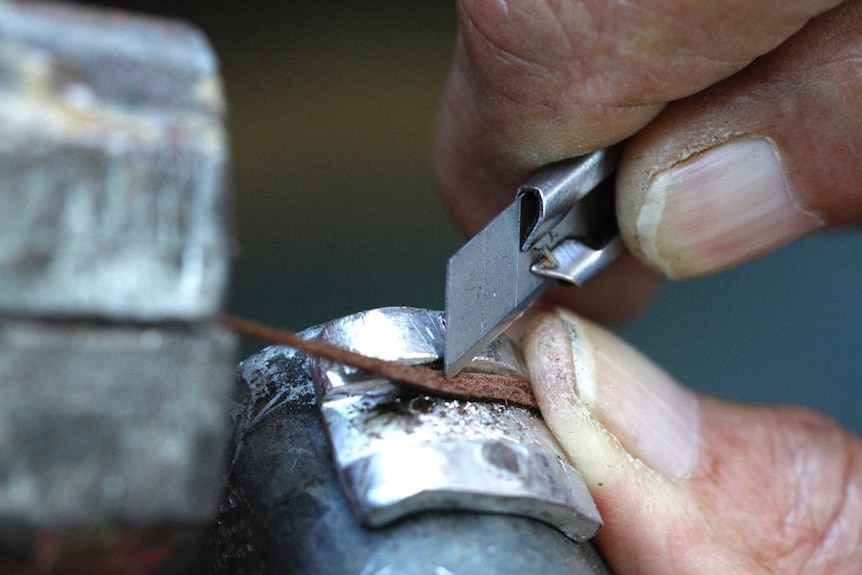 Doug Kite shaves a leather strip