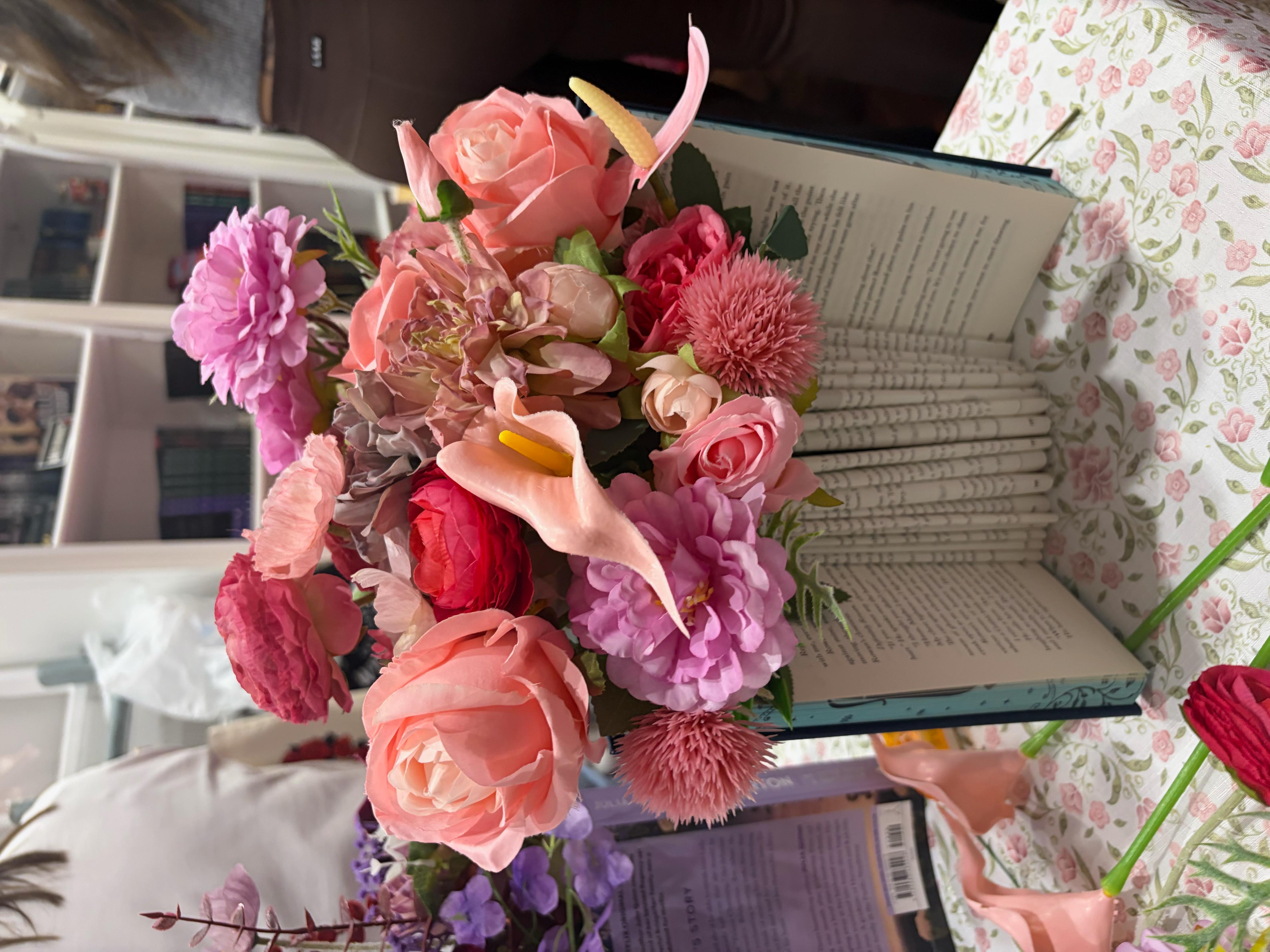 A book with pages all folded up and flowers on top of it