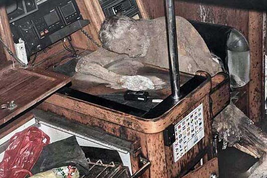 A mummified body sitting at a desk.