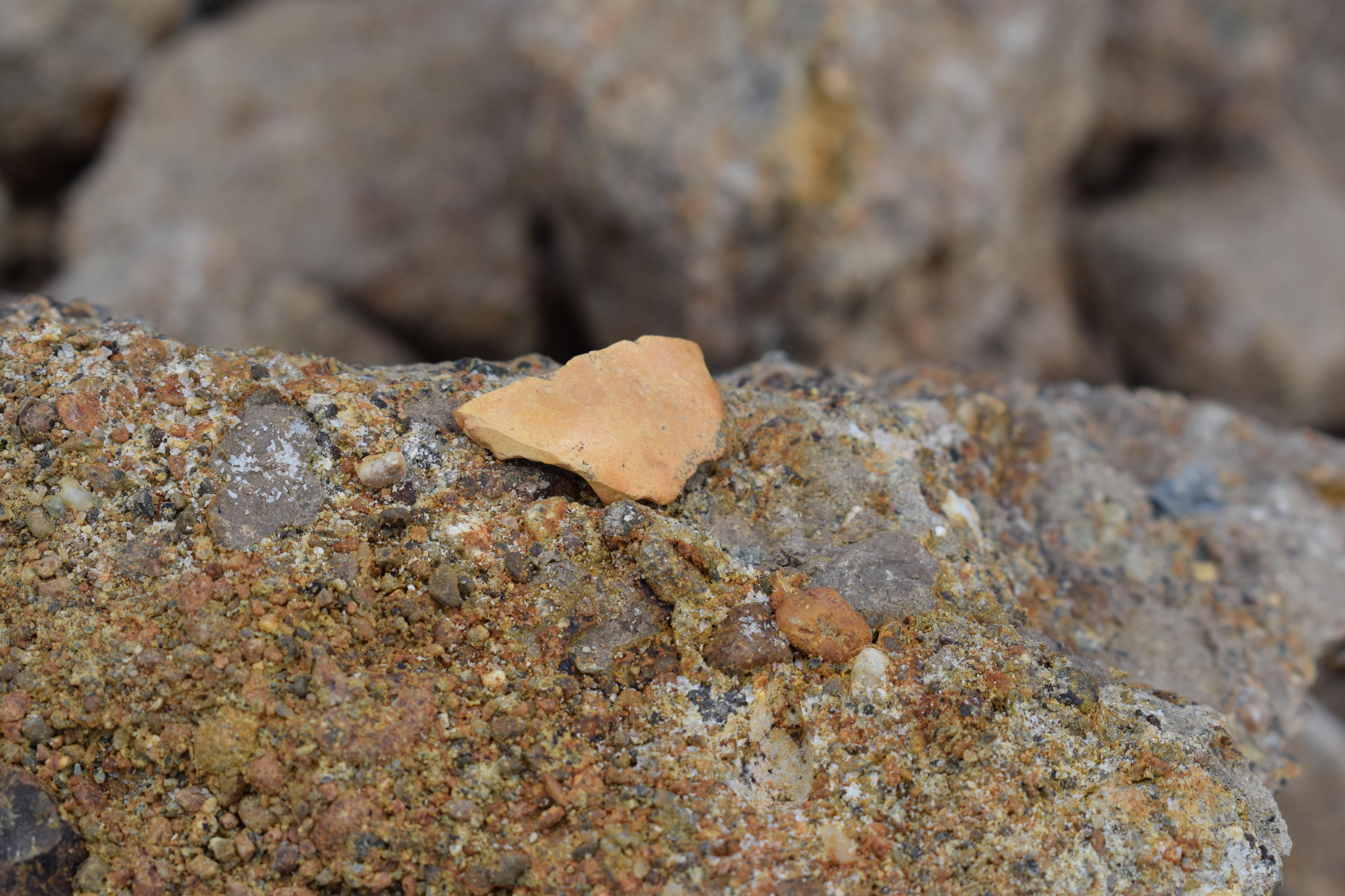 Pale, pointed teardrop-shaped rock sitting atop granite.
