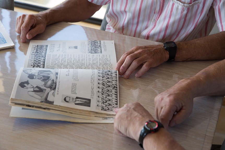 Men look at a high school year book