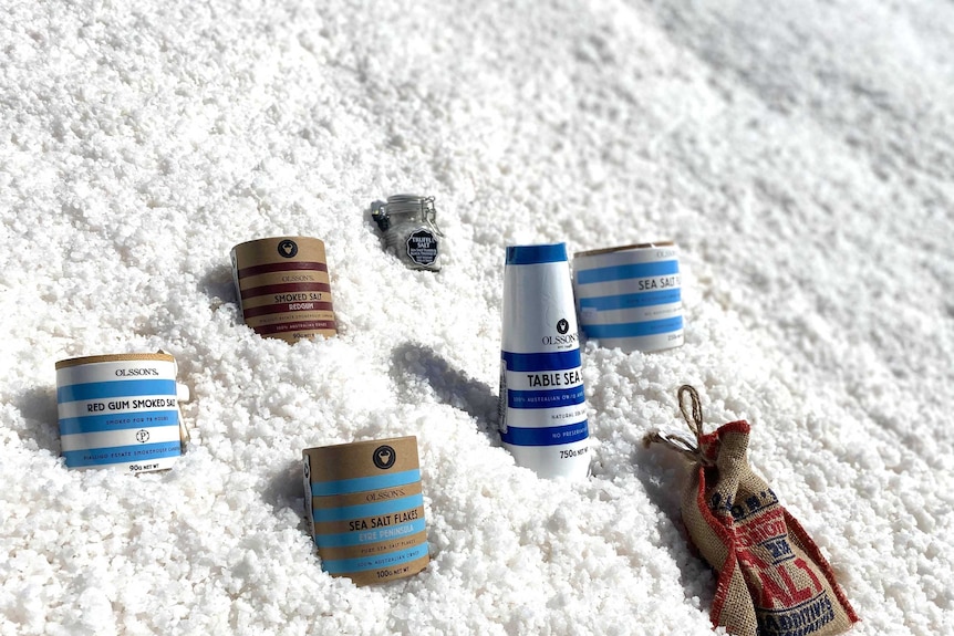 Jars and containers of salt sitting in a salt bed which belongs to a larger salt pile