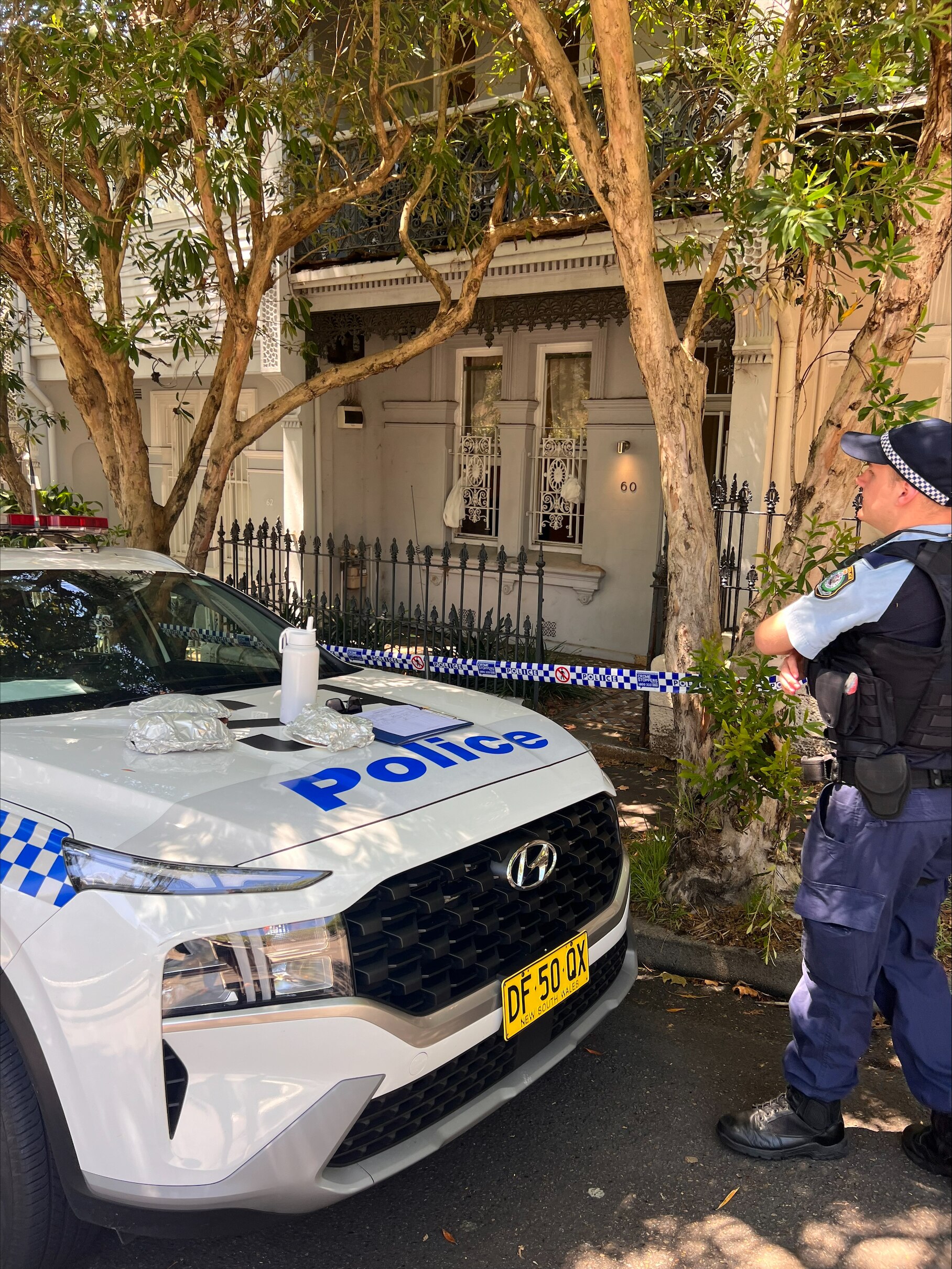 A police officer and a police car outside a house