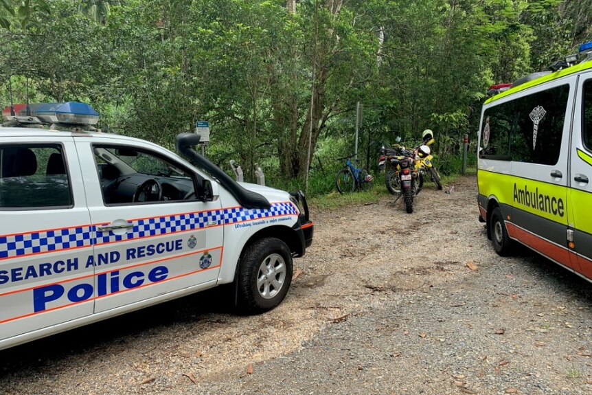 A police search and rescue van and an ambulance parked on a bush track