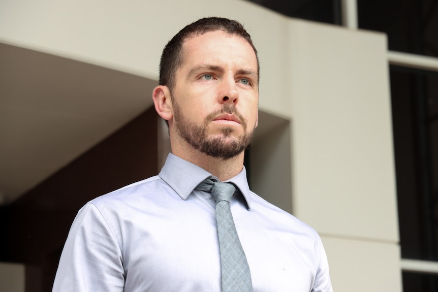 A man wearing a silver tie and blue shirt leaves the NT Supreme Court.