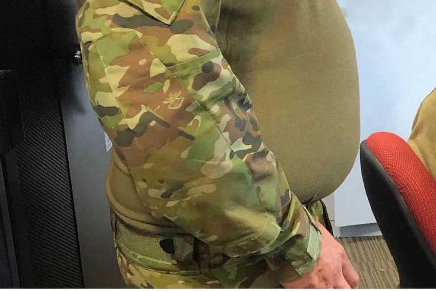 A close up image of a male soldier's stomach.