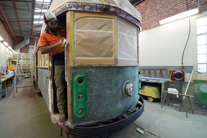A worker working on a tram shell.