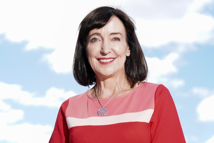 A woman with brown hair wearing a red top