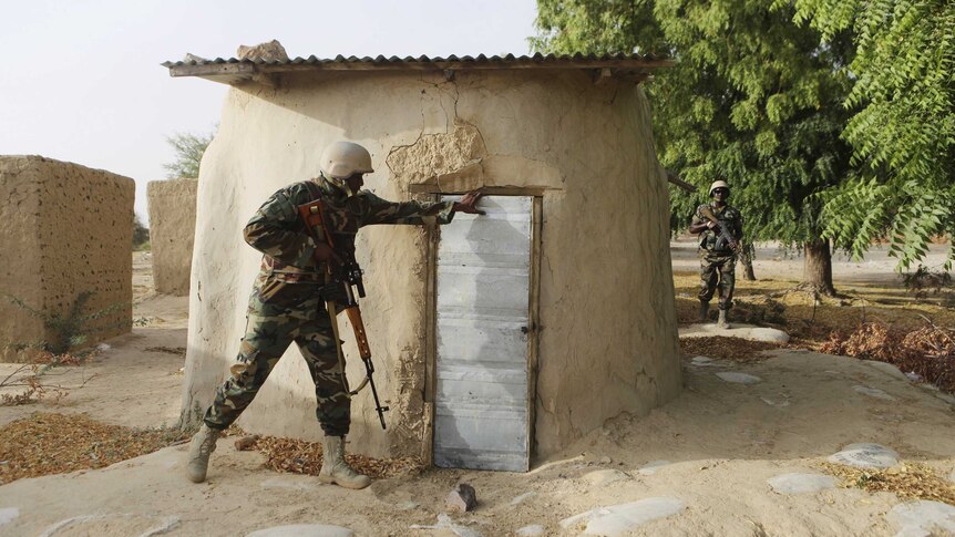 A Nigerien soldier checks a building while on patrol in Duji