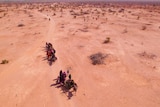A caravan of refugees in the desert.