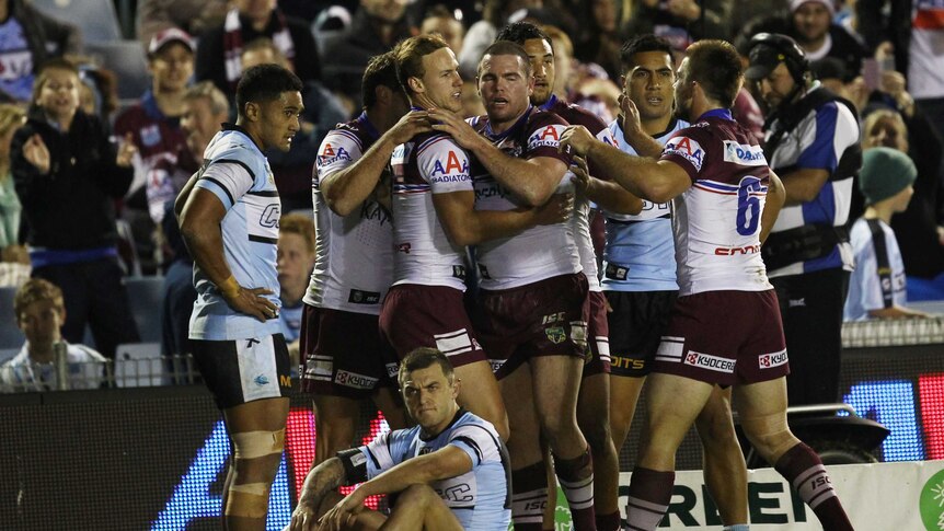 Manly players celebrate a try against Cronulla