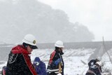 Japanese rescue workers search through snow